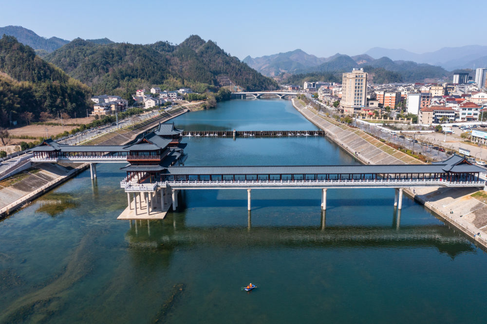 浙江省杭州市临安区昌化镇的党员志愿者在昌化溪打捞漂浮物，保持河面清洁美观（2023年3月14日摄，无人机照片）。